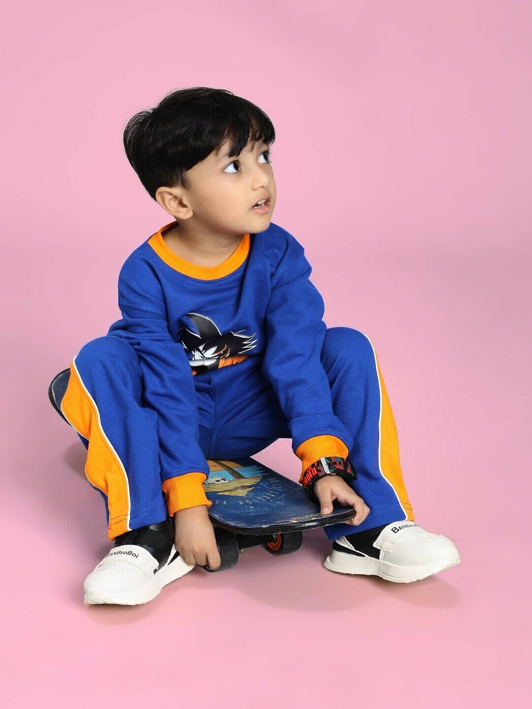 Child wearing SUPER SAIYAN CO-ORD SET FOR BOYS AND GIRLS BLUE sitting with skateboard, featuring vibrant design and comfort for active play.