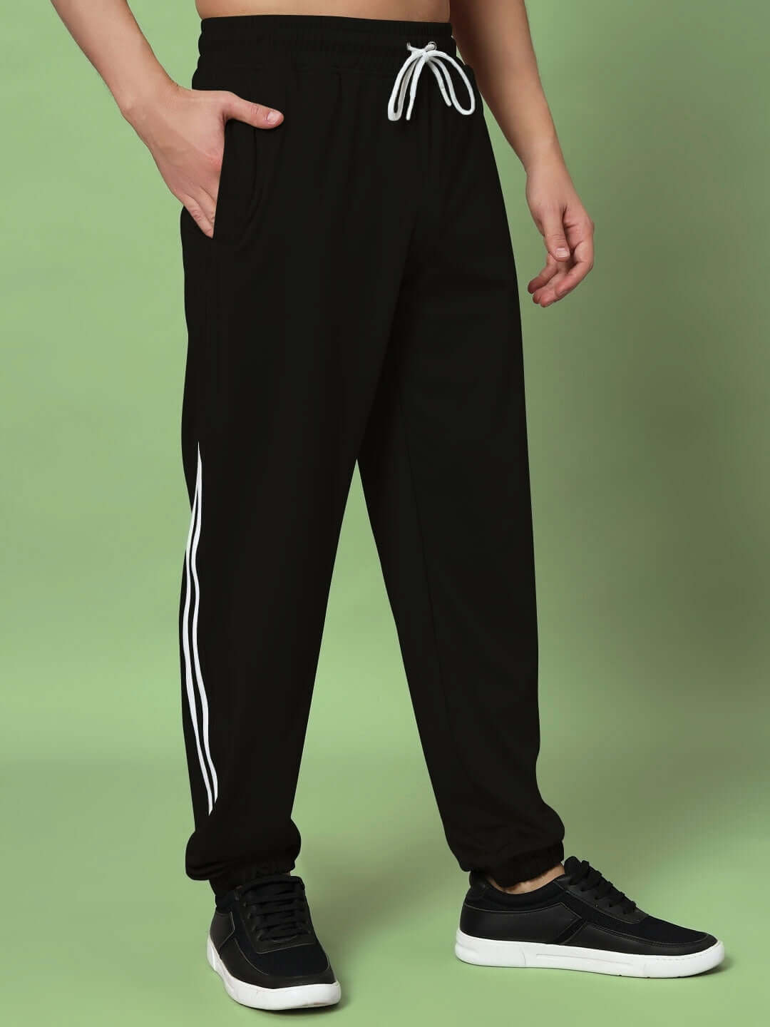 Black relaxed jogger pants with white stripes, customizable fit offered by DUDS, displayed on green background.