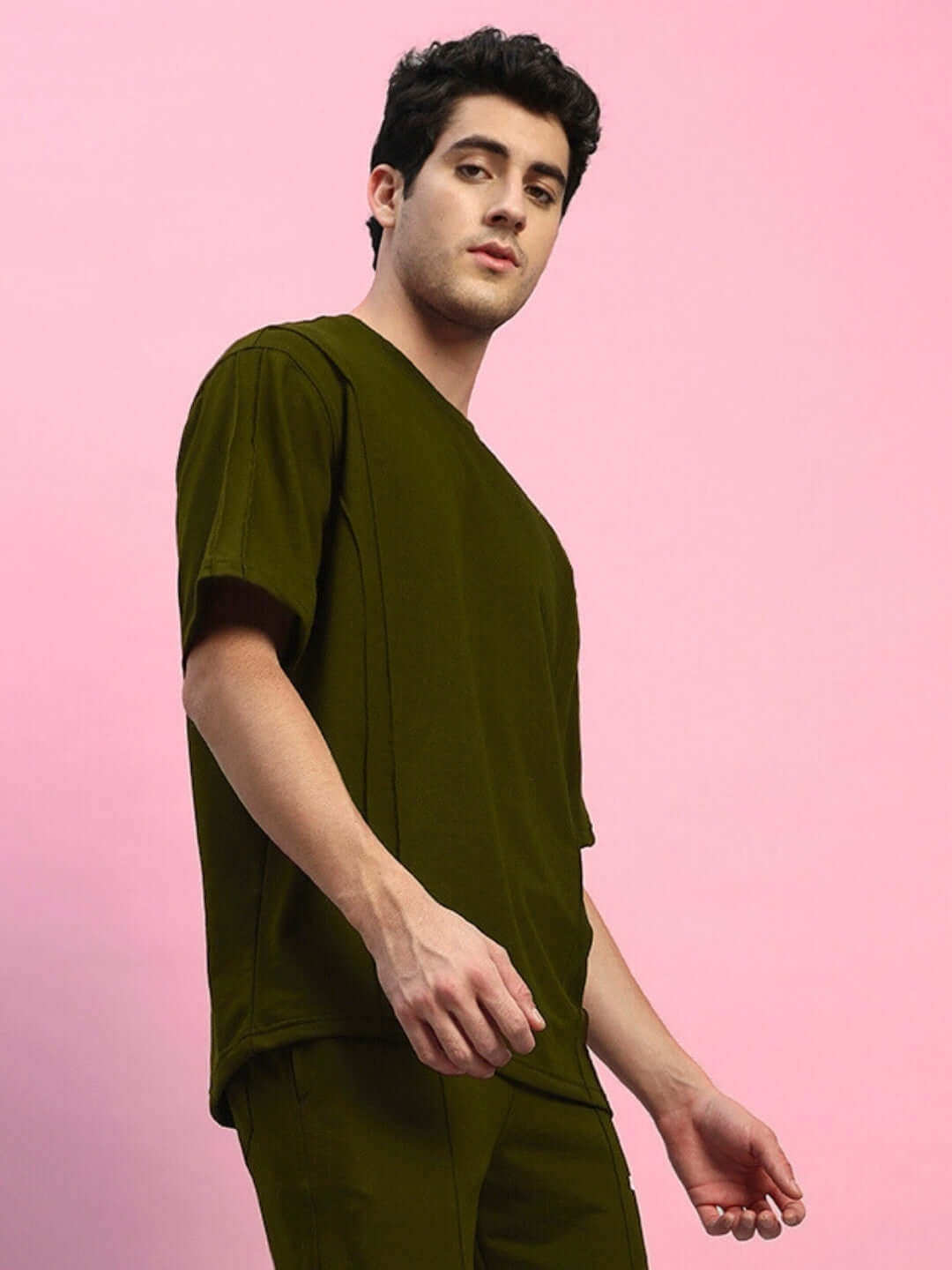 Model wearing olive green oversized t-shirt made of premium heavy gauge fabric, featuring 97% cotton and 3% elastane; perfect for comfort and style.