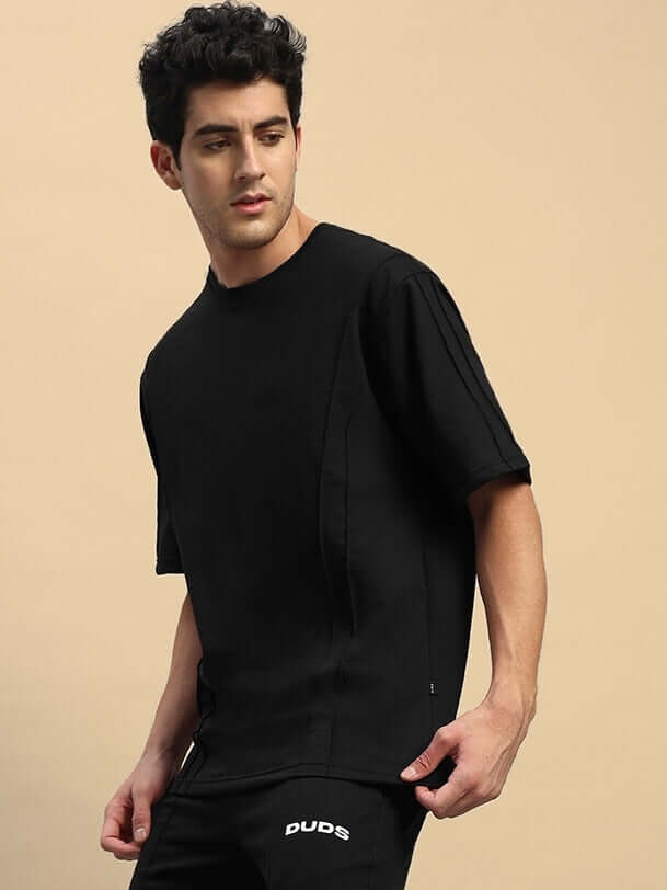 SUPERIOR OVER SIZED T-SHIRT BLACK in premium cotton-blend, relaxed fit for comfort, worn by a model showcasing style and versatility.