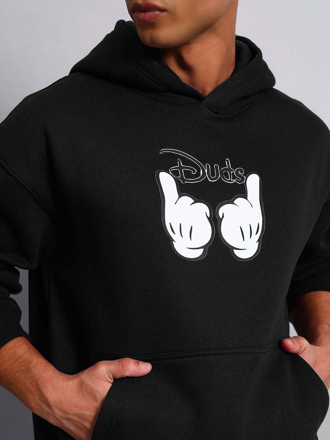Close-up of WEARDUDS SUPREME FLEECE HOODIE BLACK with logo design, showcasing front pocket and hood detail.