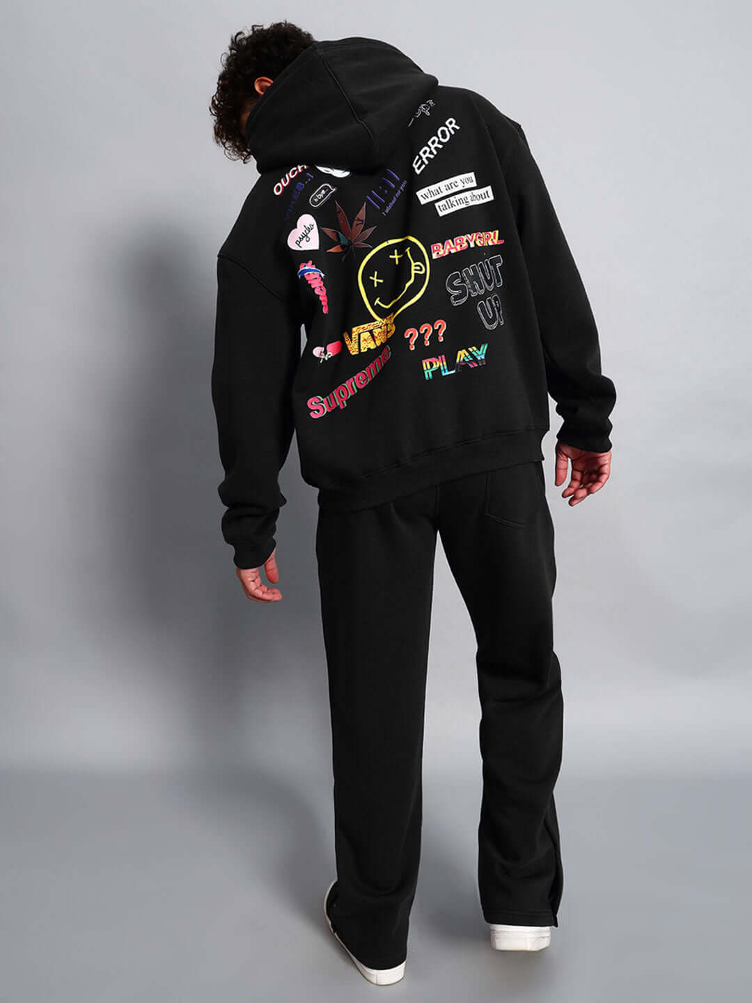 Man wearing WEARDUDS SUPREME FLEECE CO-ORD BLACK with colorful graphics on the back.