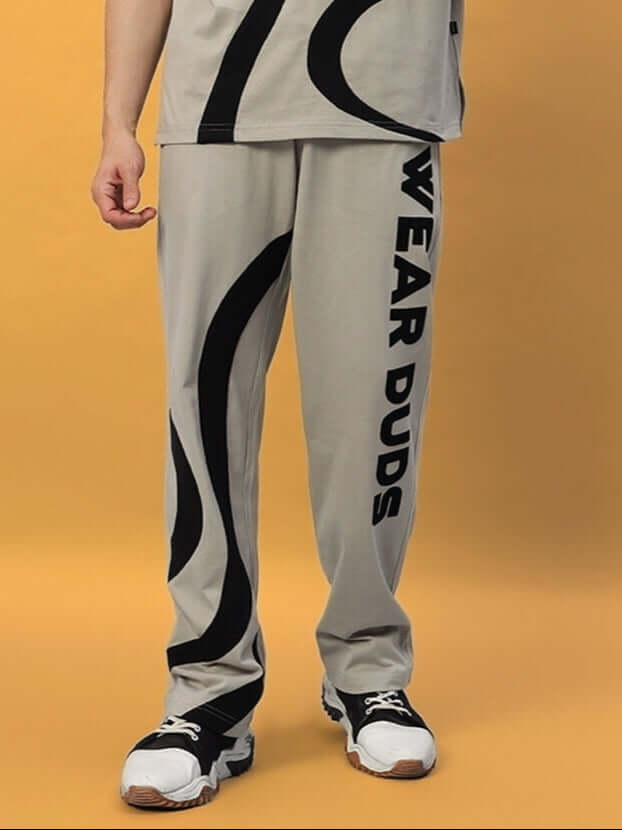 Model wearing grey surfing jogger pants by DUDS with bold black design, highlighting comfortable fit and stylish look.