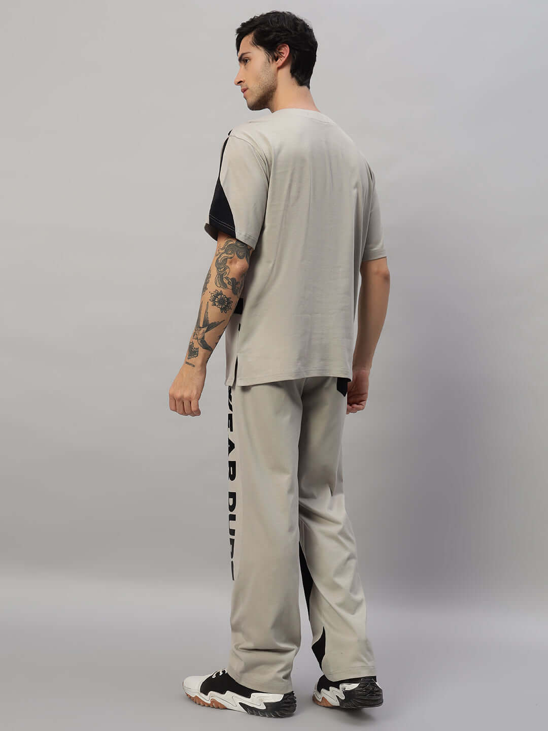 Model wearing SURFING OVERSIZED CO-ORD SET GREY with unisex relaxed fit joggers, elasticated waistband, and contrast panel design.