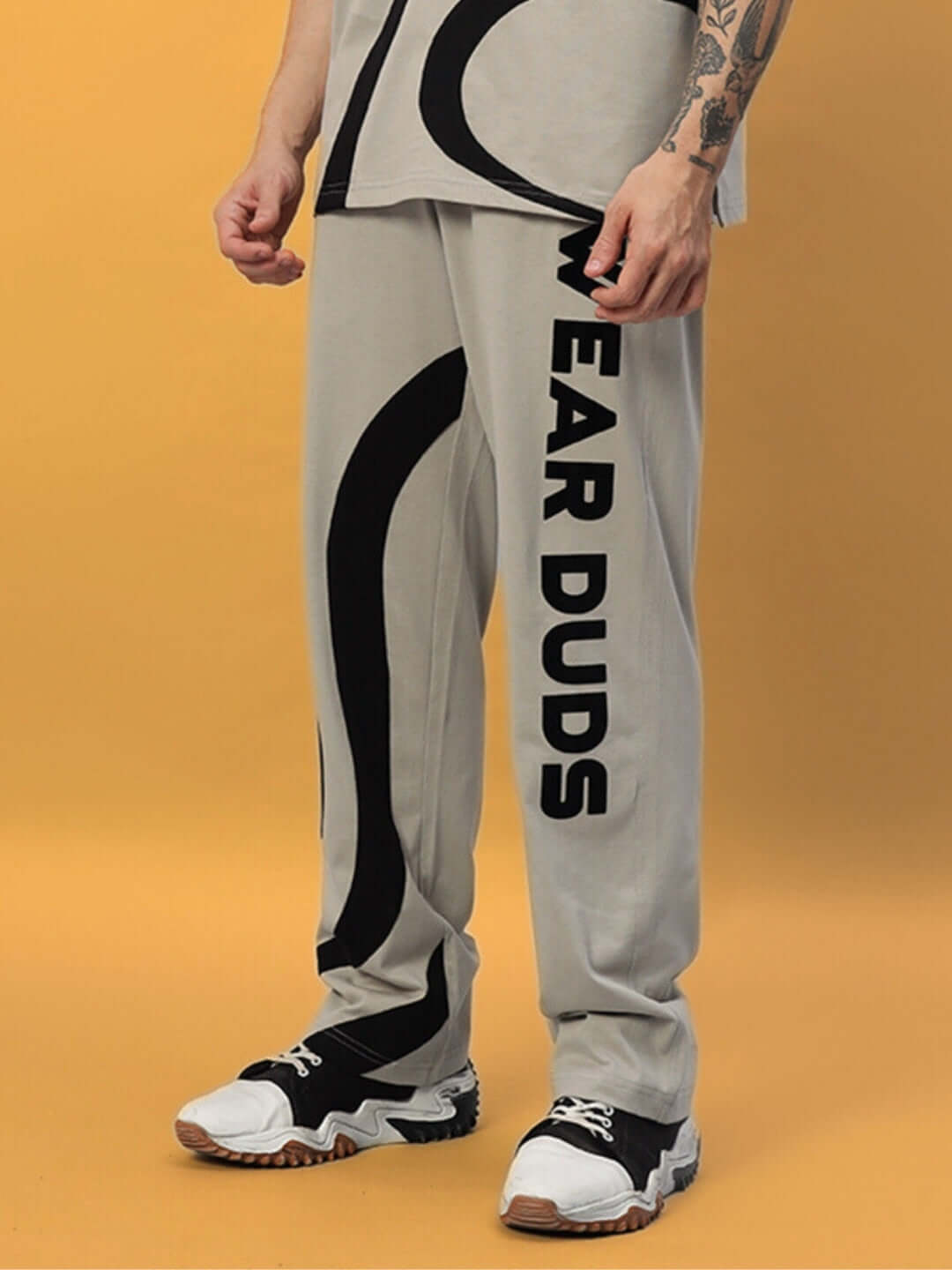 Alt Tag: Grey surfing jogger pants by DUDS, featuring bold black graphic design, crafted by skilled tailors for a perfect fit.