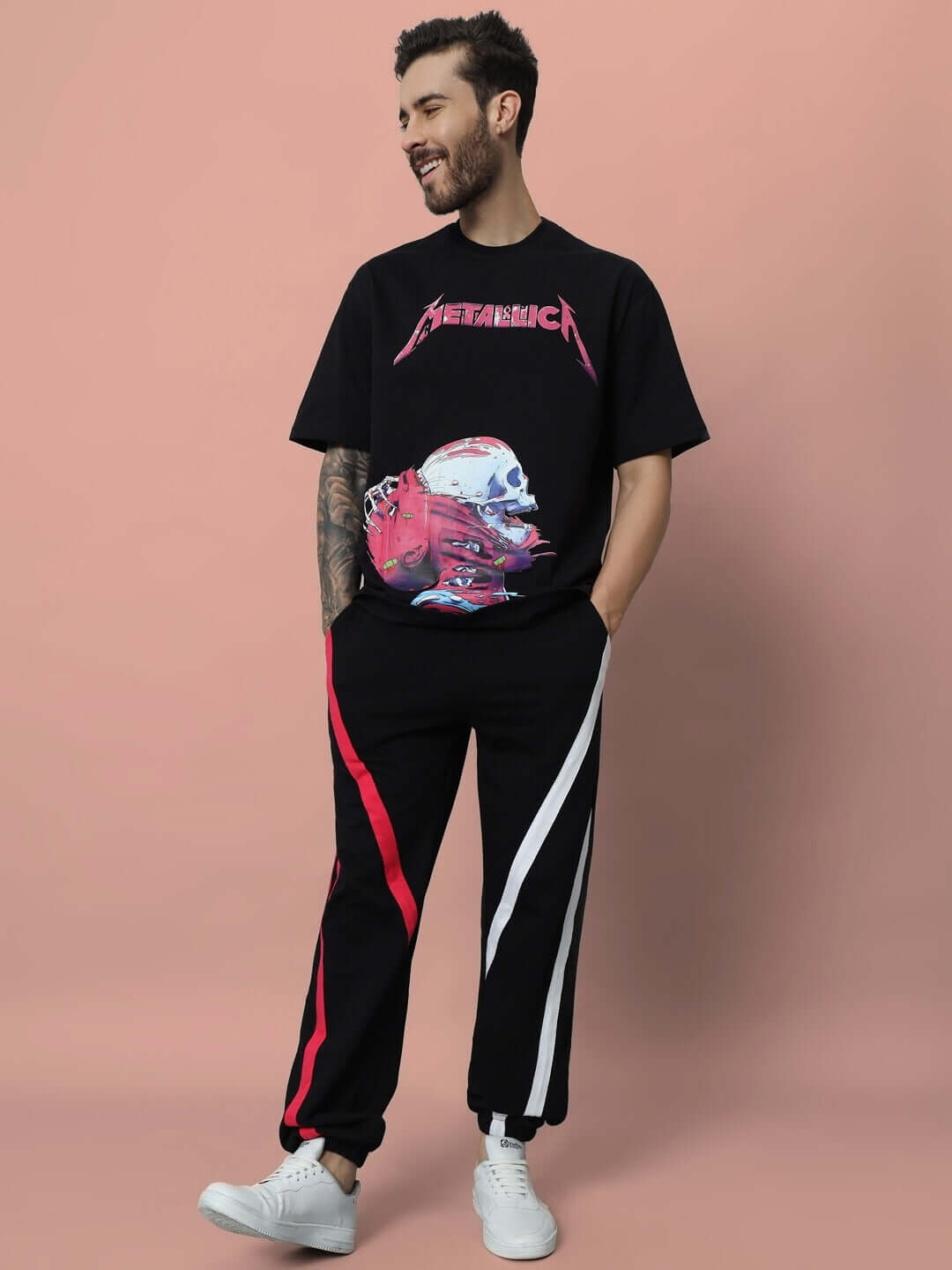 Man wearing black SWATHE colorful stripe joggers with graphic T-shirt, featuring a casual style in a studio setting.