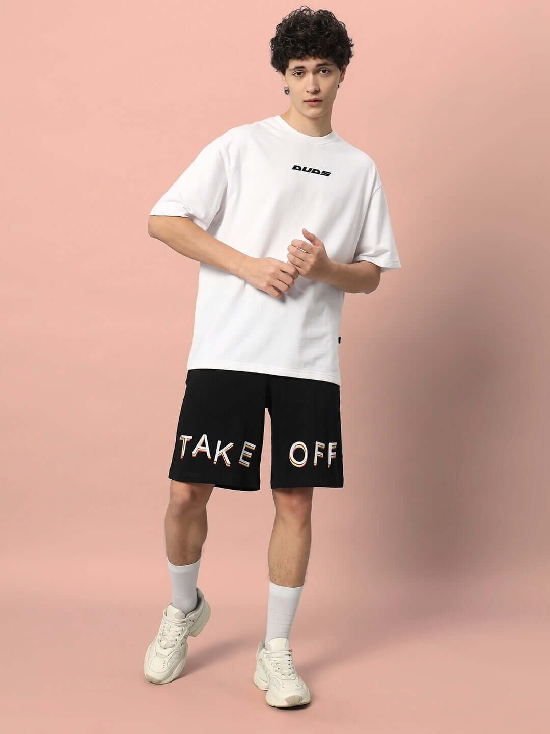Model wearing black 'TAKE OFF' regular fit shorts with optional custom sizing feature available for a personalized fit, designed by DUDS.