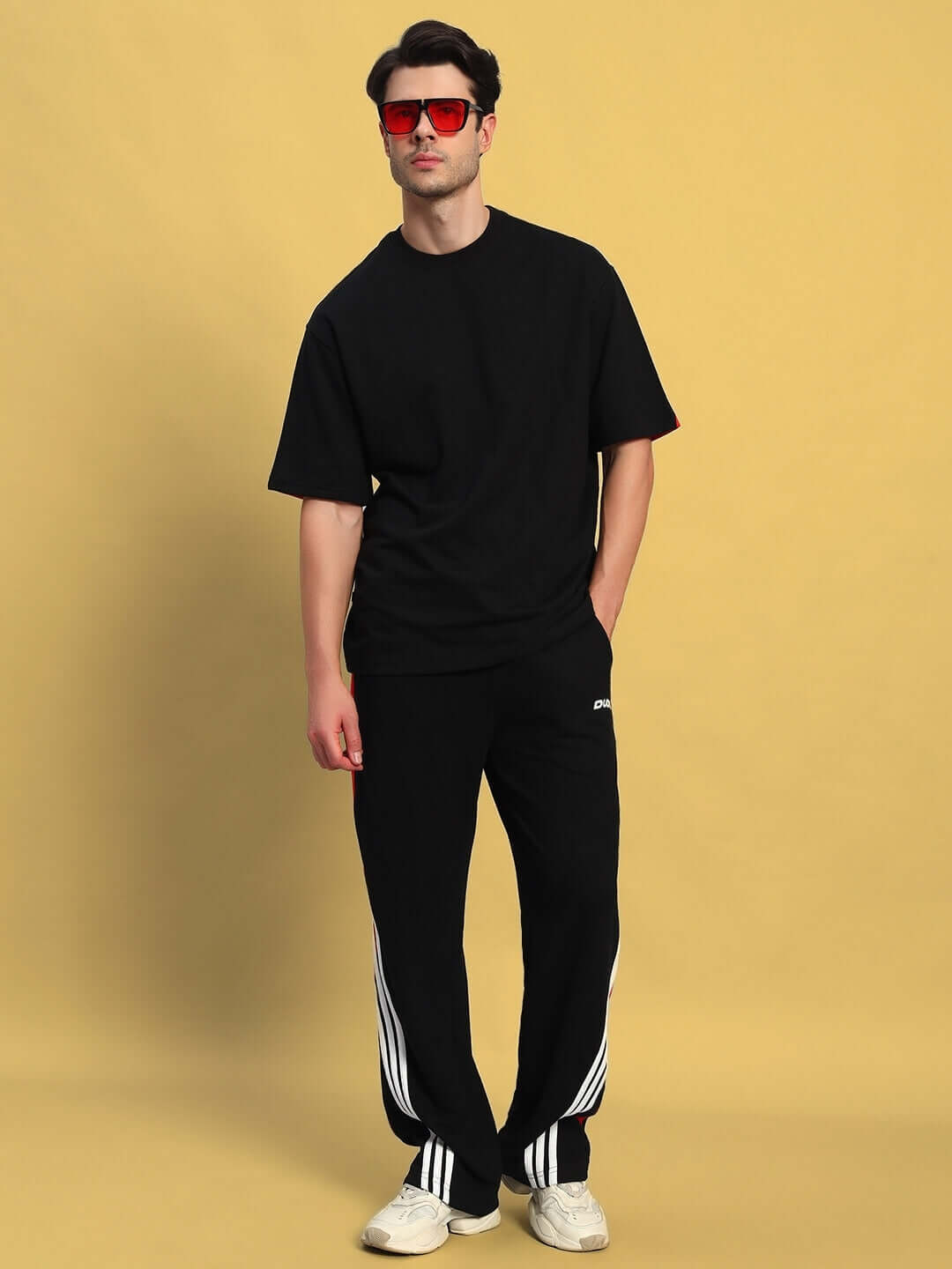 Model wearing TANGLE relaxed-fit joggers in black-red with casual t-shirt, showcasing a stylish and comfortable look.