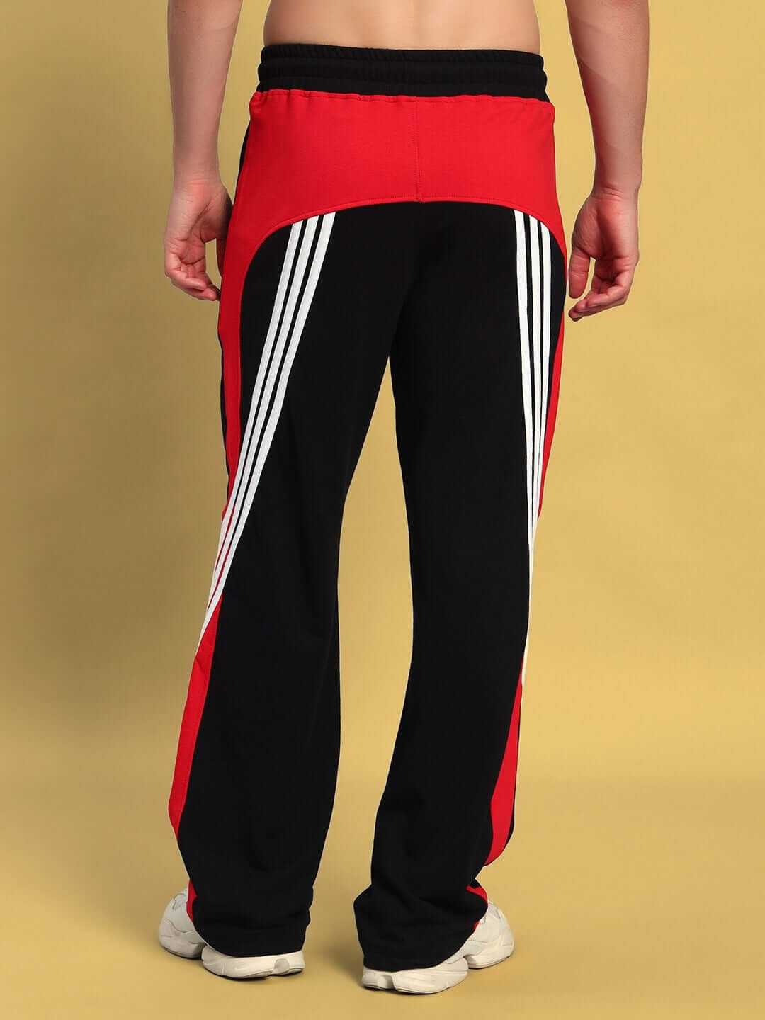 Back view of TANGLE Relaxed-Fit Joggers in black and red, featuring sporty stripes. Tailor-made design by DUDS.