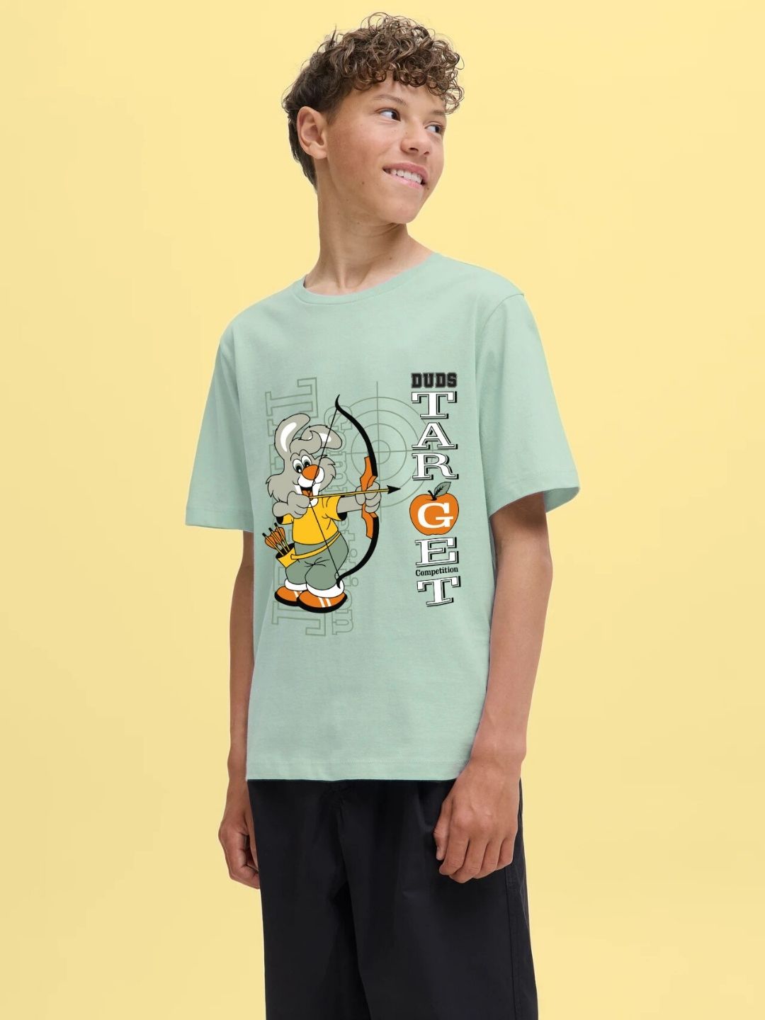 Boy wearing TARGET PRINTED T-SHIRT FOR BOYS AND GIRLS LIGHT GREEN with playful design, posing confidently.