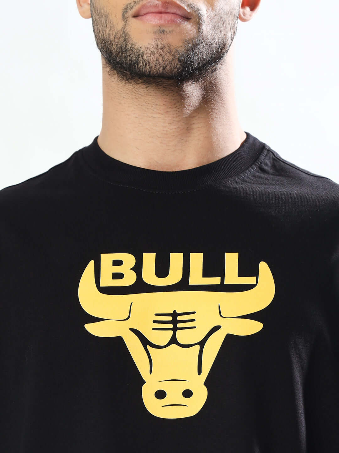 Man wearing black Taurus over-sized T-shirt with yellow bull graphic and 'BULL' text, customizable fit available for prepaid orders.