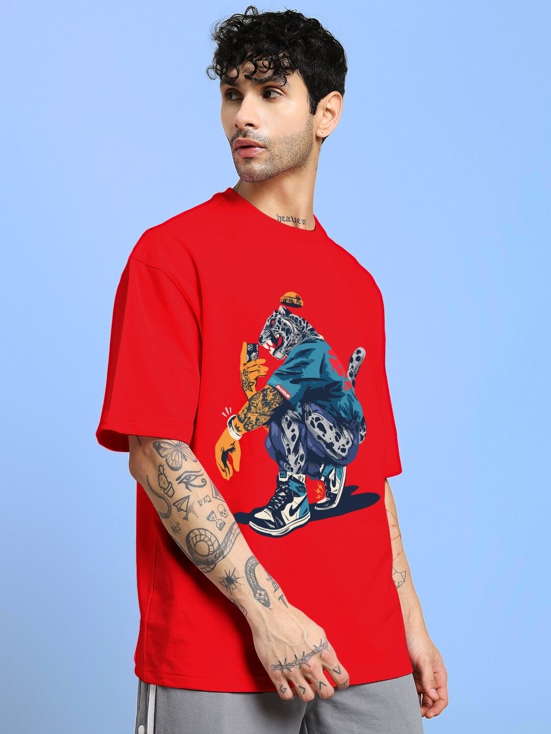 Model wearing TEKKEN KING T3 OVER-SIZED T-SHIRT RED with graphic design on front.