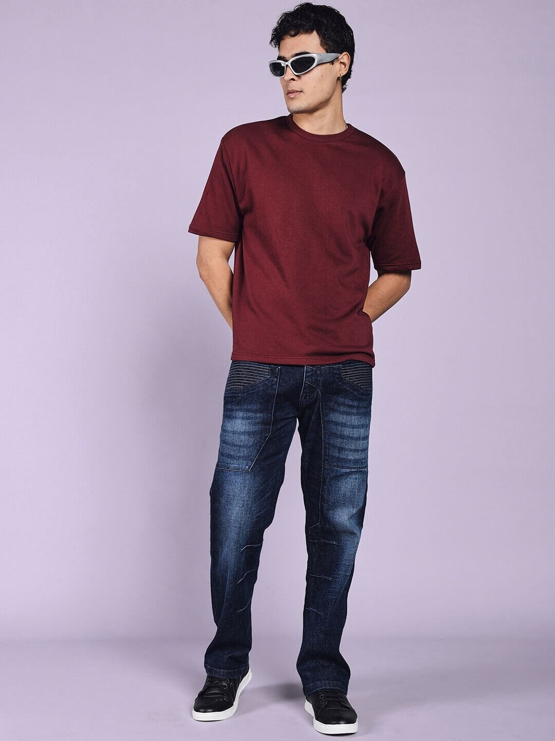 Model wearing Thrifty Regular Fit Denim Jeans in dark blue with sunglasses, styled with a maroon shirt, showcasing casual fashion.