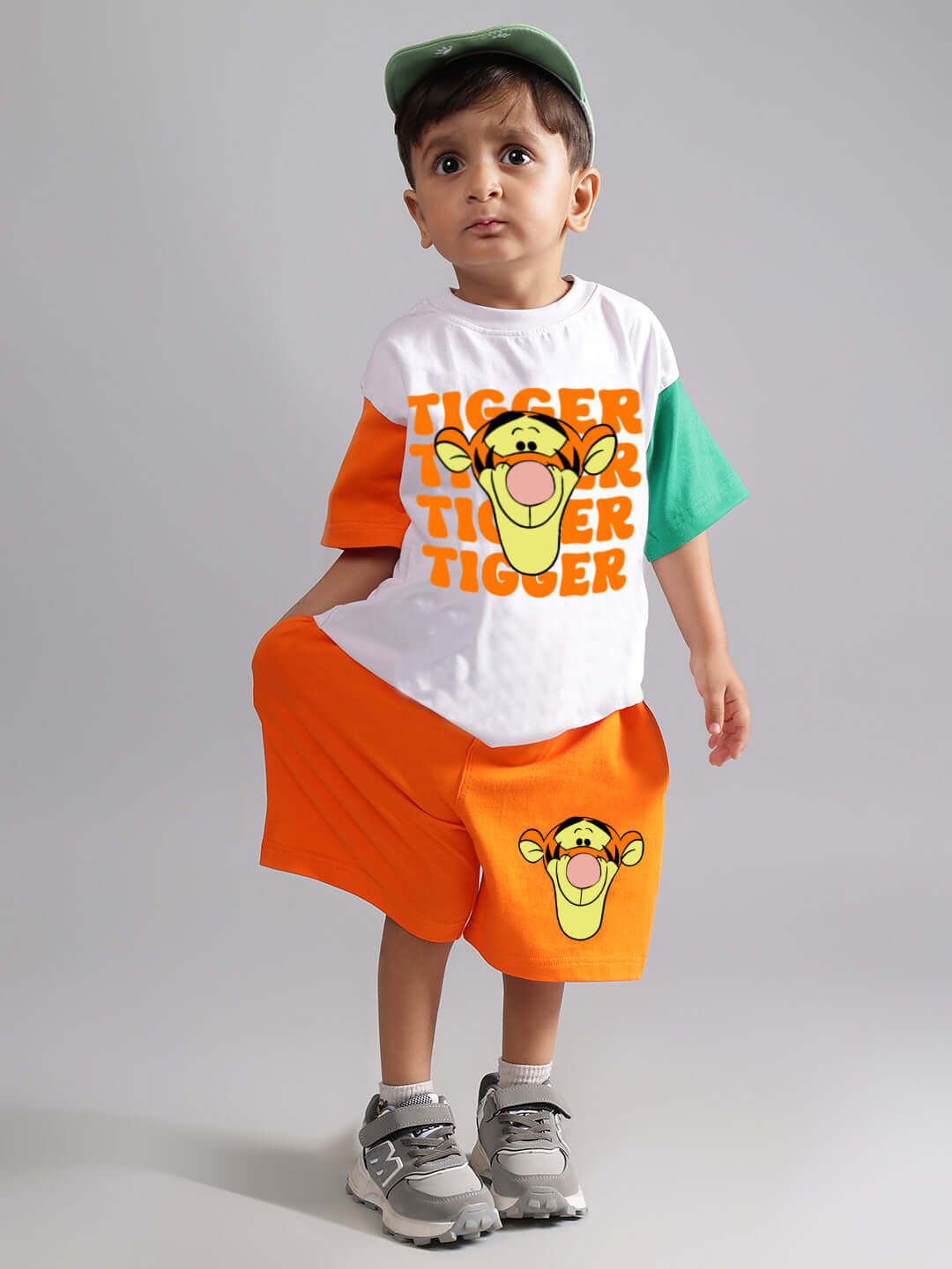 Child wearing a colorful Tigger-themed oversized t-shirt and shorts set, featuring vibrant orange and green accents.