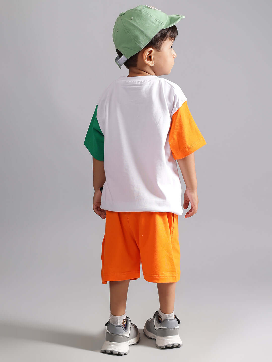 Child wearing orange tiger shorts and a colorful t-shirt, back view, showcasing vibrant and comfortable clothing for boys and girls.