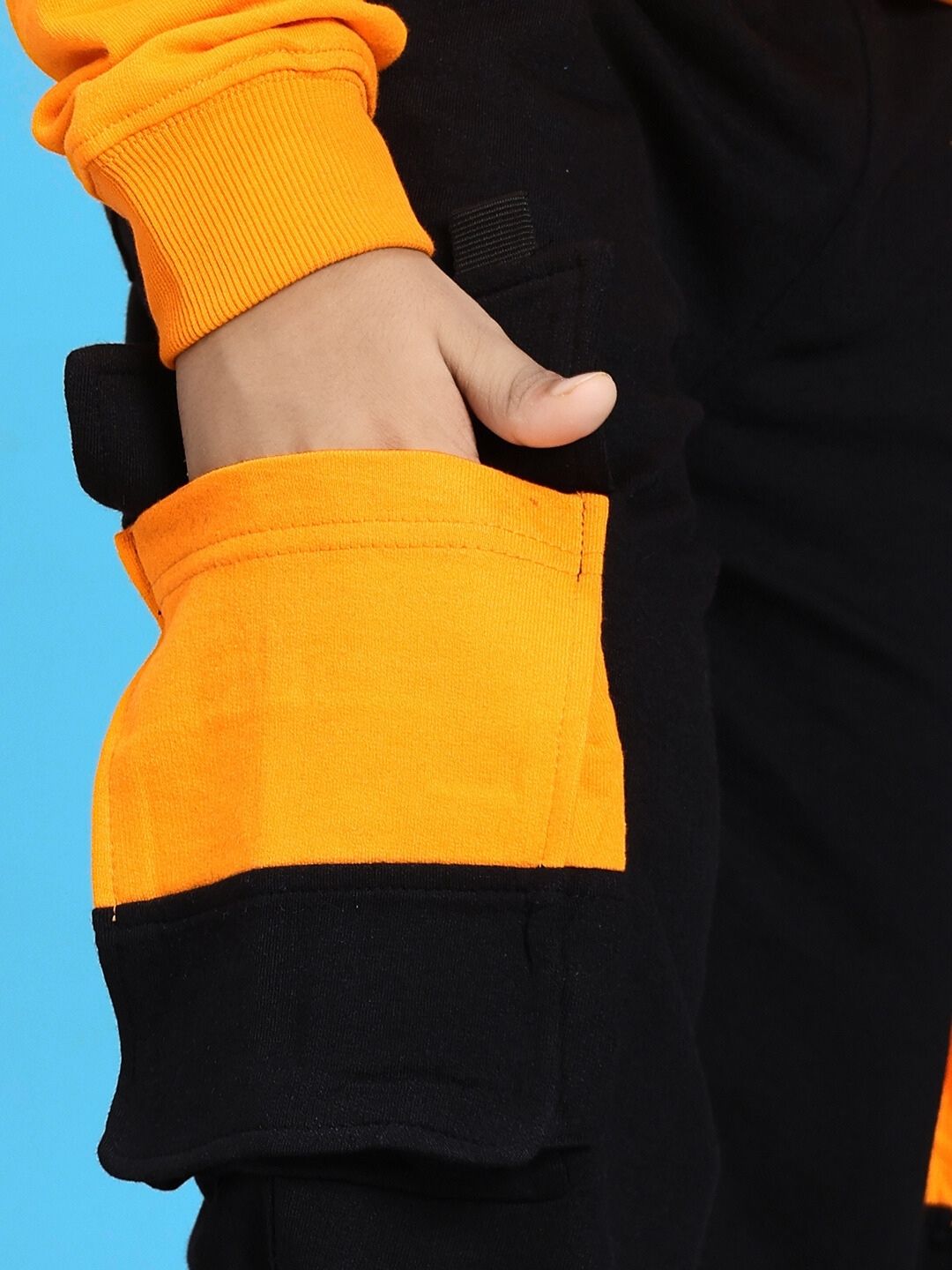 Child wearing TIGON KIDS JOGGER FOR BOYS AND GIRLS RED BLACK with hand in pocket, showcasing stylish black and orange contrast design.