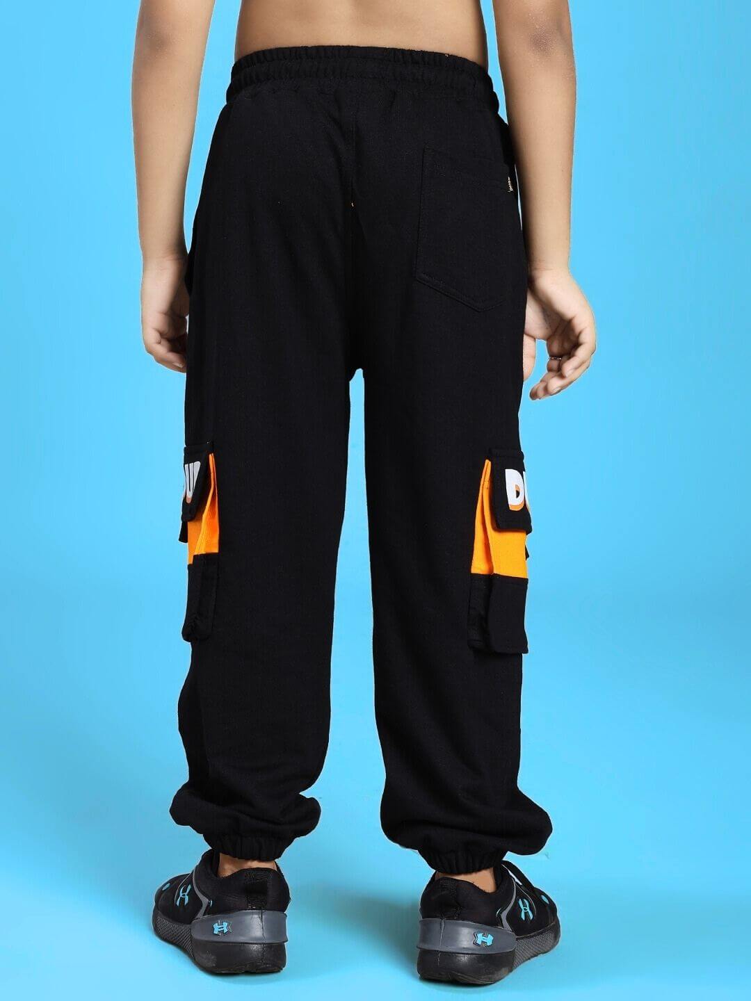 Back view of a child wearing TIGON KIDS JOGGER FOR BOYS AND GIRLS RED BLACK with cargo pockets, black with orange accents.