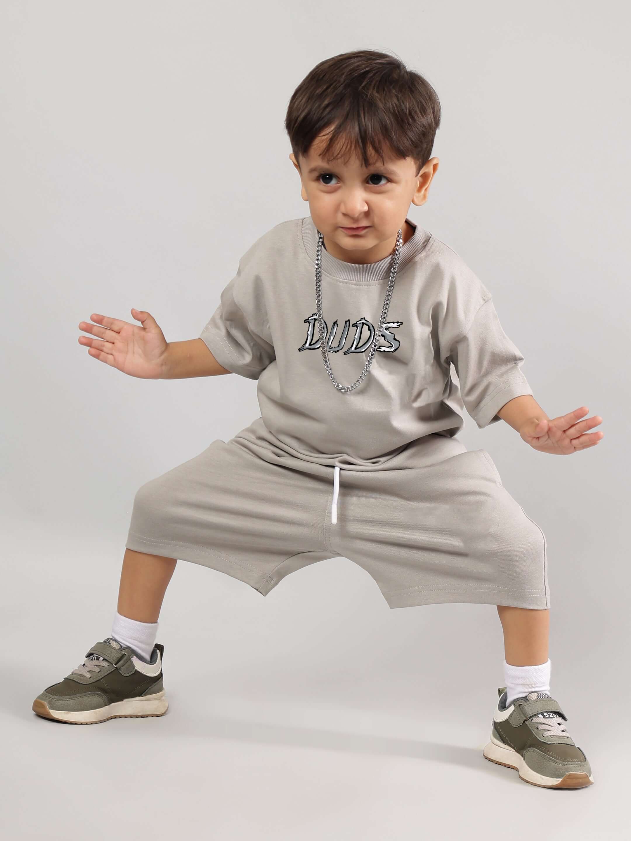 Child wearing a grey DUDS positive rabbit t-shirt and shorts set, posing confidently. Ideal for boys and girls, comfortable and stylish.
