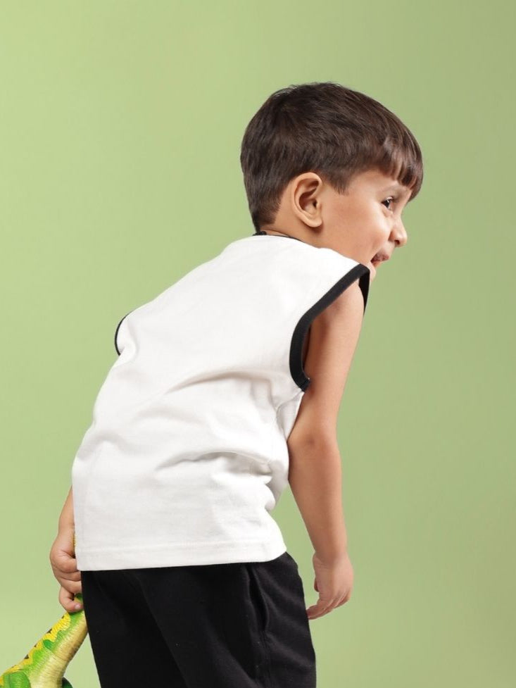 Boy wearing off white Blue Cat summer t-shirt for boys and girls, showing the back view against a green background.