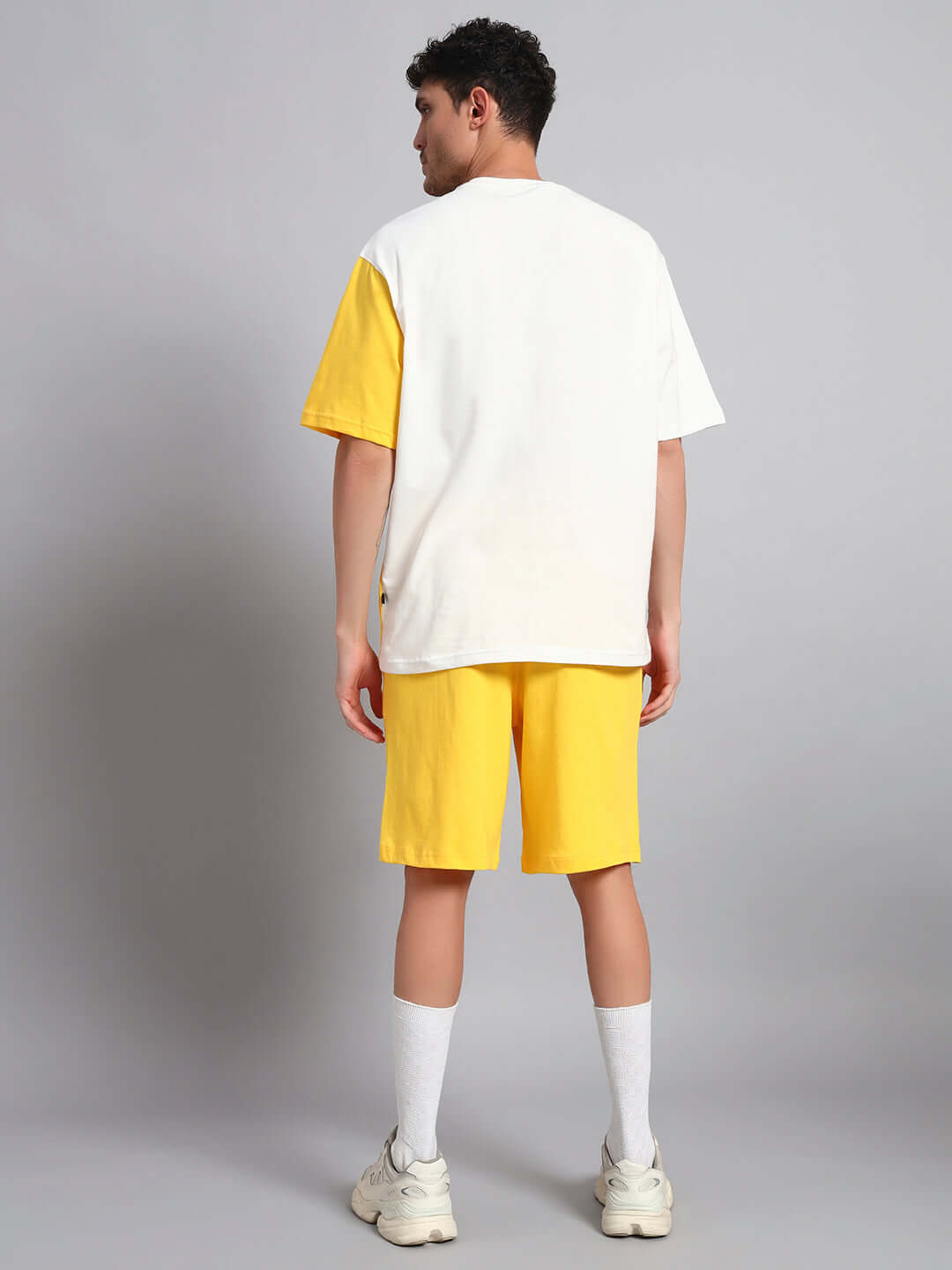 Man wearing yellow and off-white Tom & Jerry co-ord set, showcasing premium cotton French Terry fabric, back view.