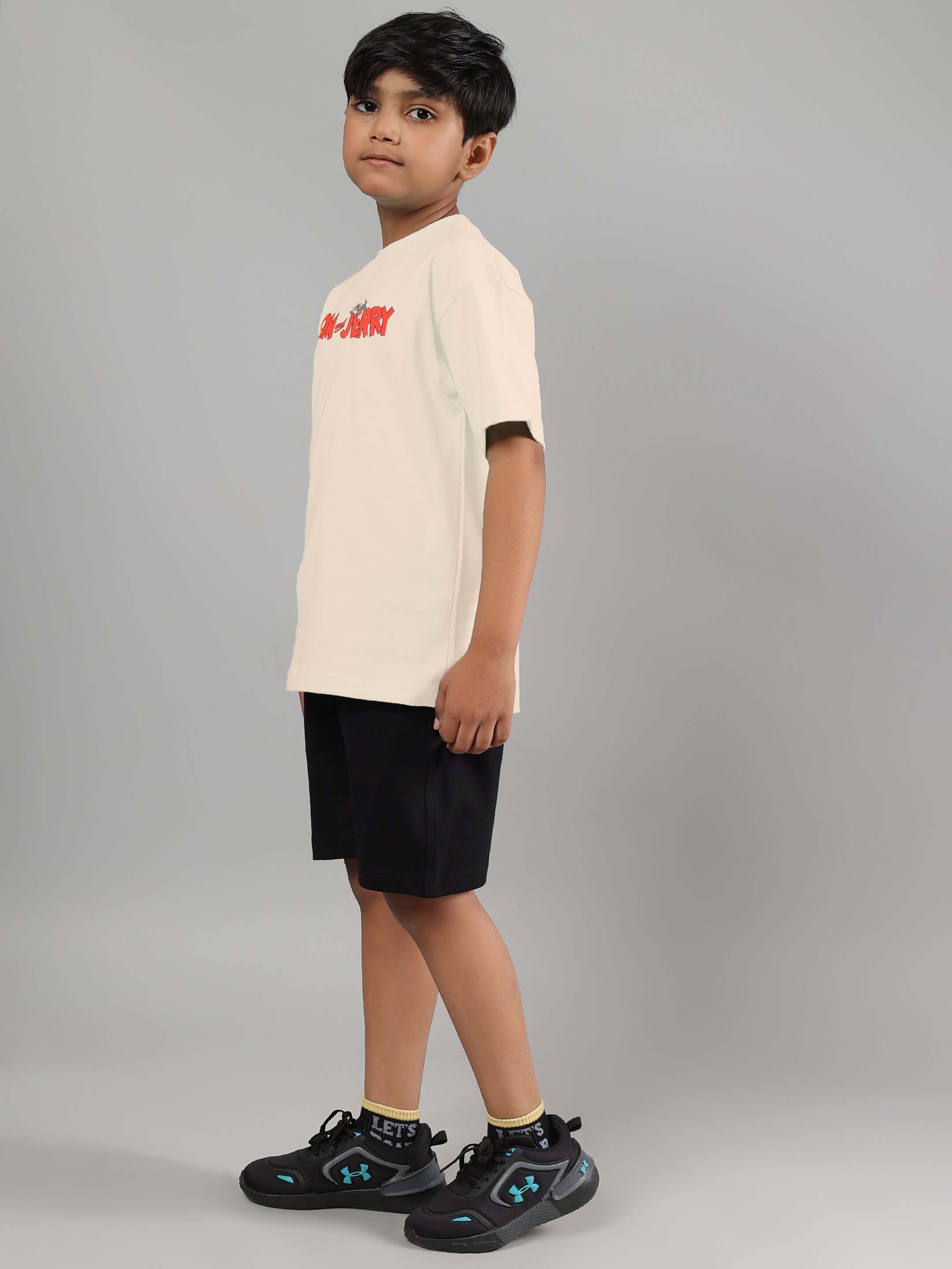 Boy wearing off white and black Tom & Jerry co-ord set, featuring a casual t-shirt and shorts, suitable for boys and girls.