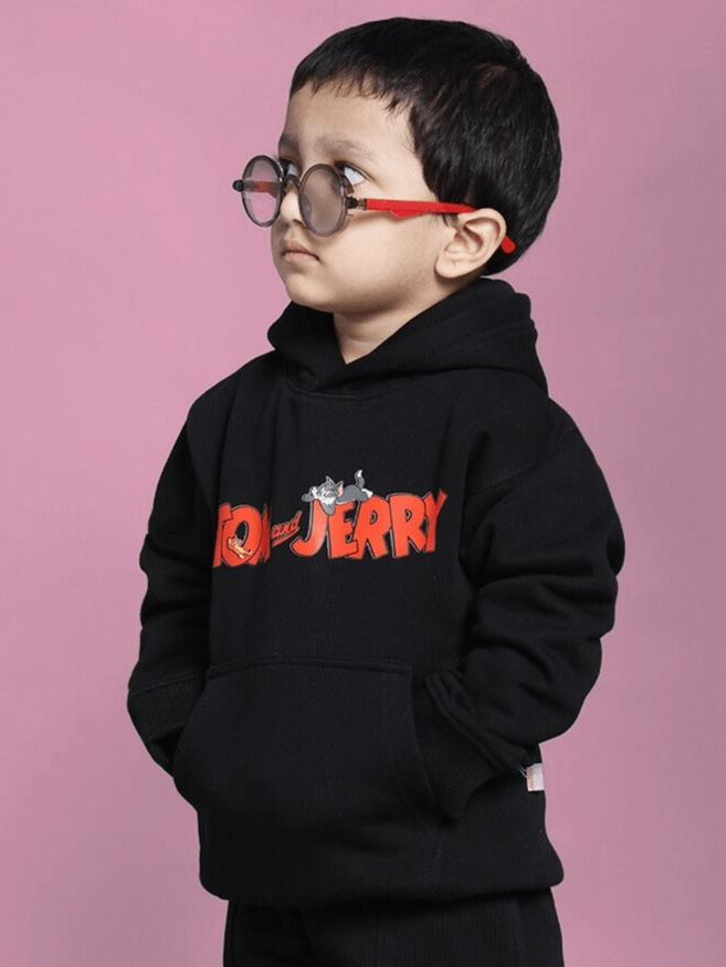 Child wearing black Tom and Jerry oversized hoodie for kids, featuring colorful cartoon characters.