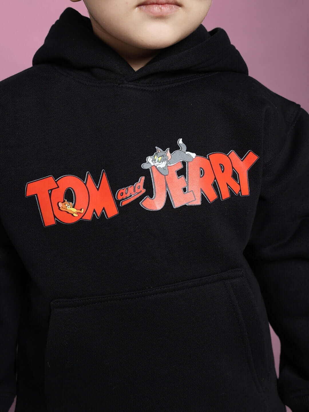 Child wearing a Tom & Jerry black co-ord hoodie featuring cartoon logo.