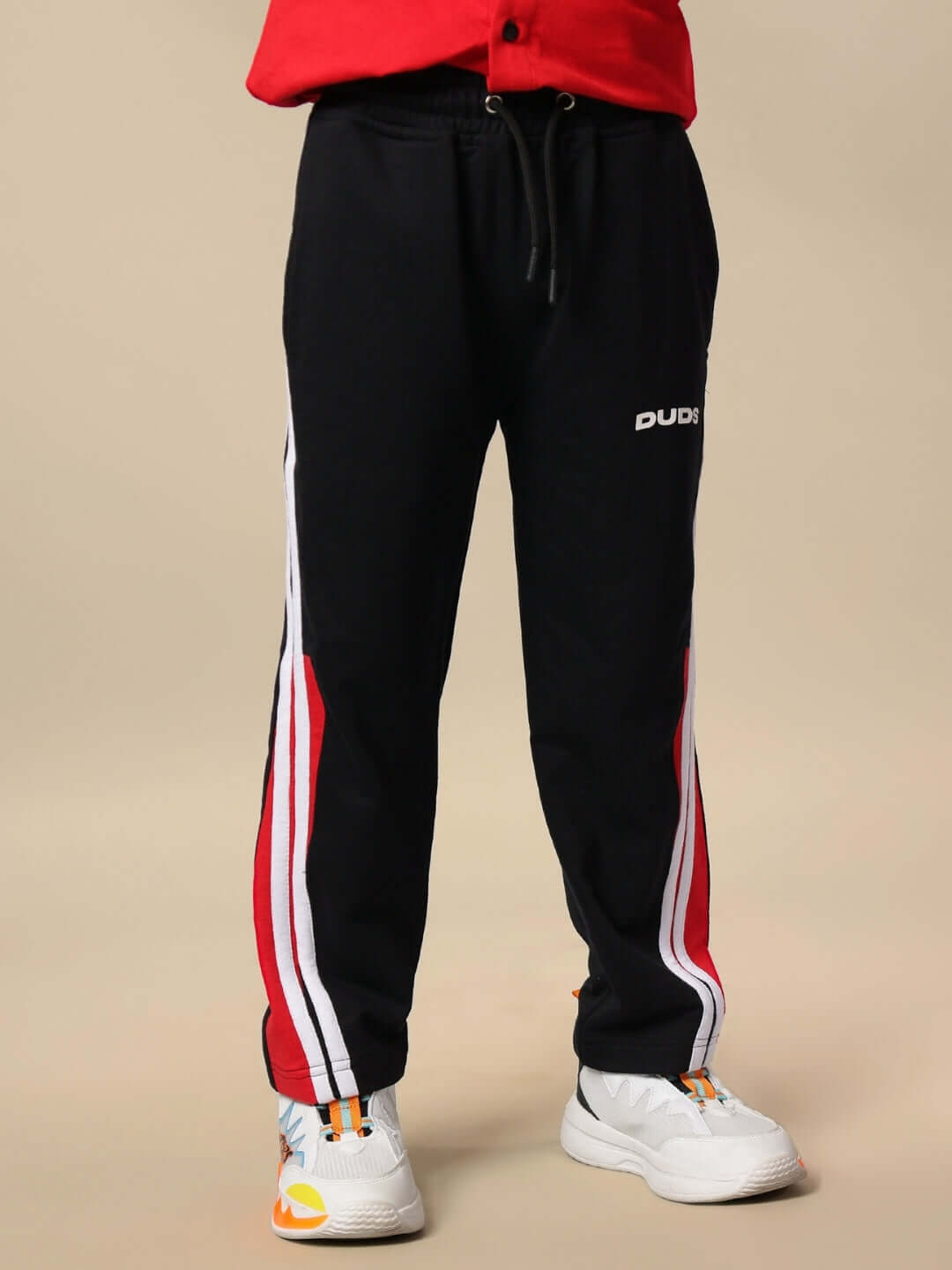 Child wearing TORNADO JOGGER FOR BOYS & GIRLS BLACK with red and white stripes, highlighting sporty and stylish streetwear design.