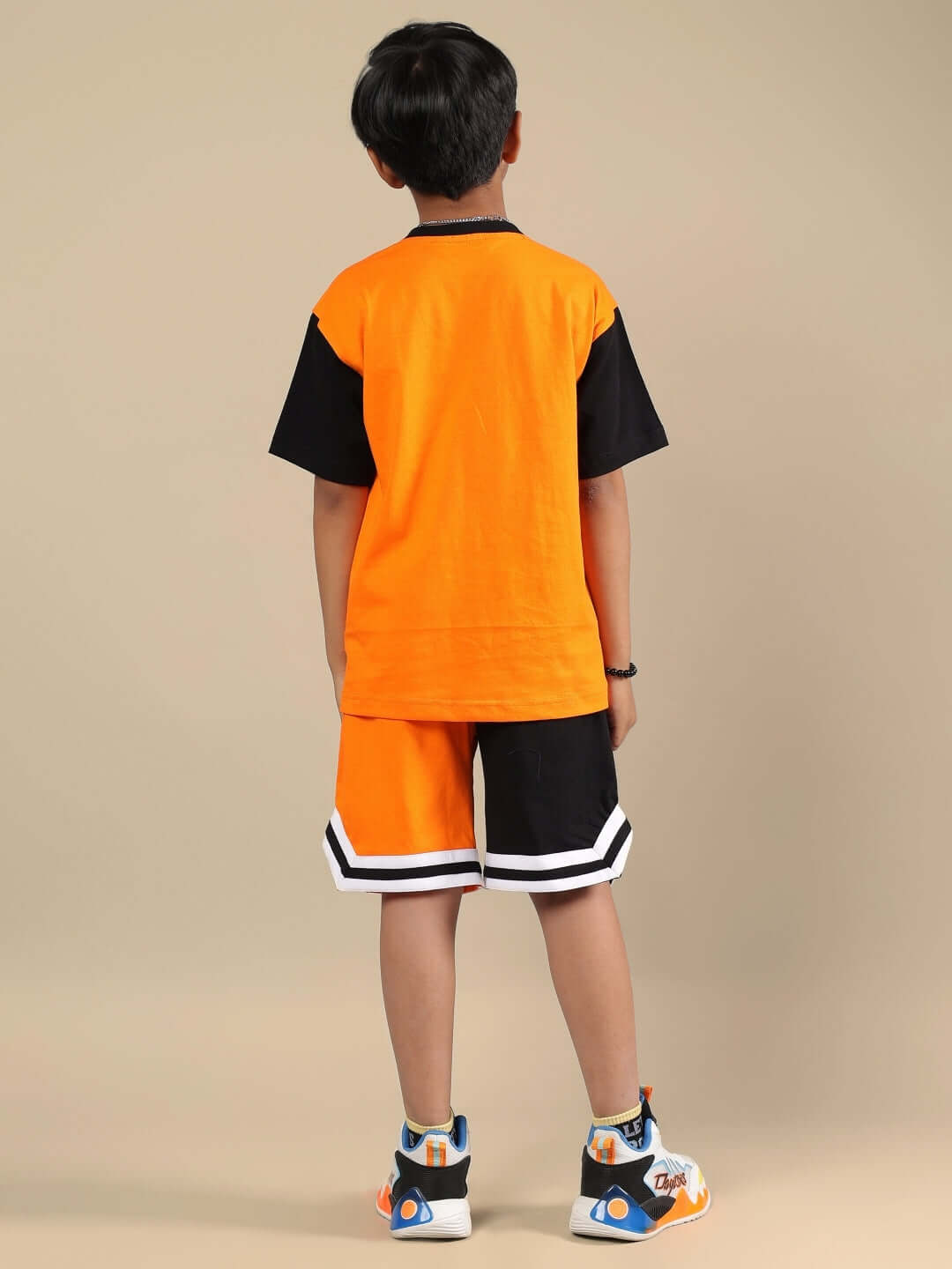 TRACK & FIELD CO-ORD FOR BOYS & GIRLS ORANGE BLACK Boy wearing orange and black track and field co-ord set for kids, featuring a stylish design, perfect for active wear.