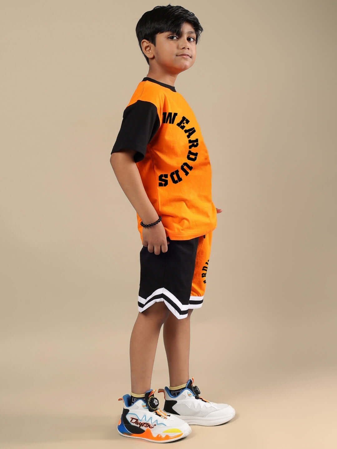 TRACK & FIELD CO-ORD FOR BOYS & GIRLS ORANGE BLACK Child wearing orange and black track and field co-ord set, featuring custom fit option. Made to order by DUDS. Ideal for boys and girls.