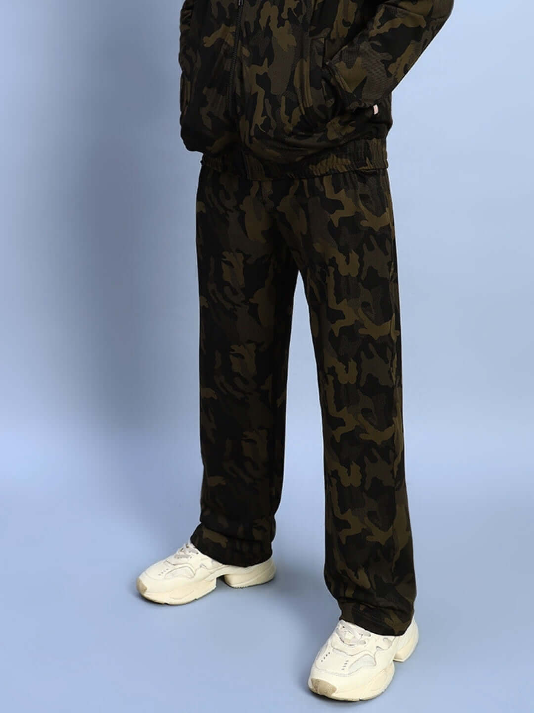 Model wearing Trench Relaxed Pant Jogger in camo green, showcasing stylish, comfortable design by DUDS, paired with white sneakers.