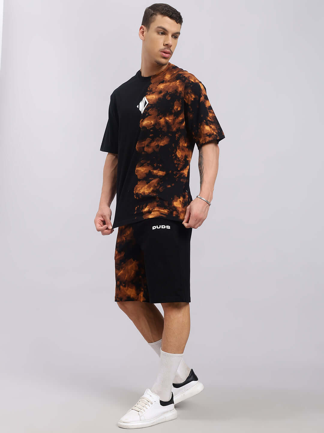Trickster tie-dye co-ord set in black, featuring premium cotton terry fabric and stylish design, modeled by a male in sneakers.