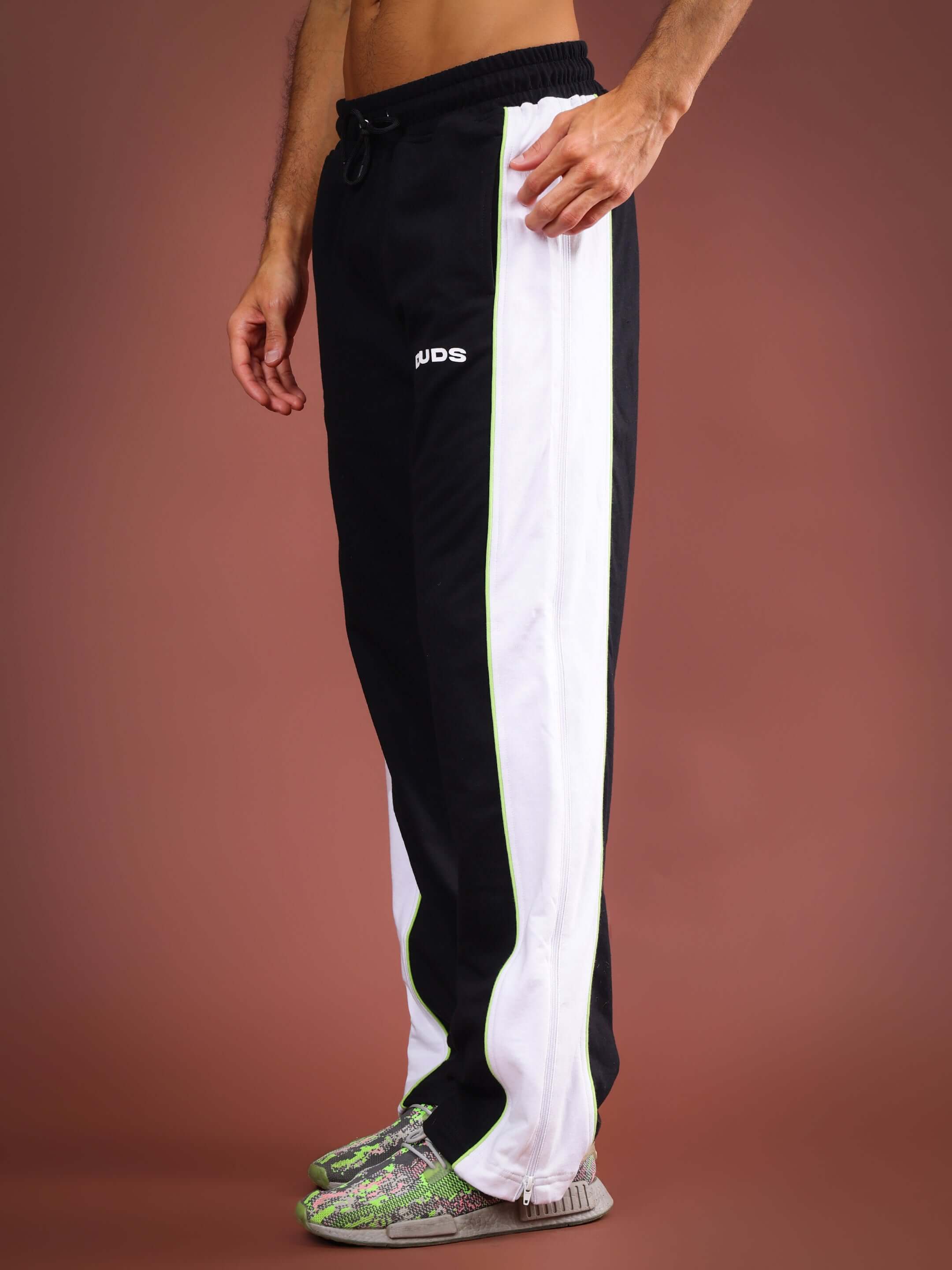 Side view of Triumph Multi Zipper Joggers in black neon, featuring white side stripes and a logo, worn by a model.