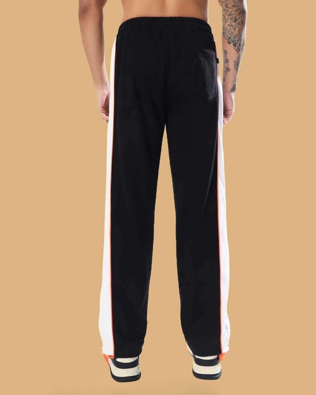 Back view of the Triumph Multi Zipper Joggers in black and orange, highlighting the straight fit and dual side stripes.
