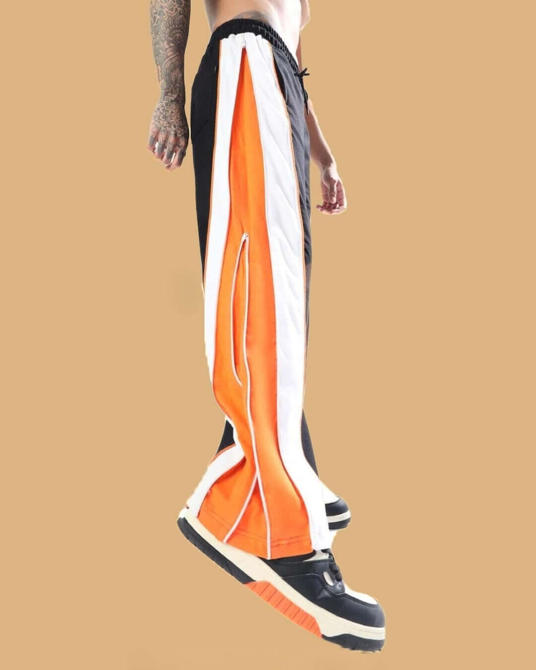 Side view of Triumph Multi Zipper Joggers in black and orange, showcasing sporty design and vibrant colors.