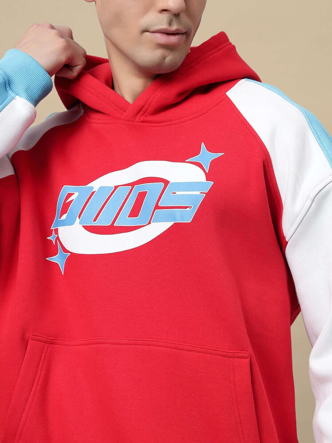 Man wearing TRUNKIT COLORBLOCK red hoodie with DUDS logo, showcasing stylish, made-to-order design.