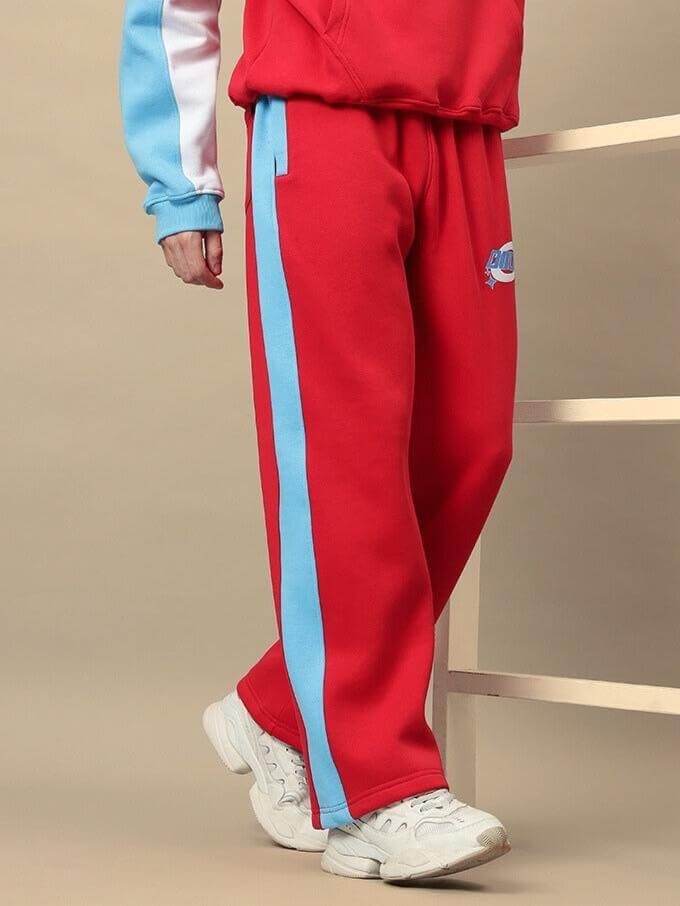Person wearing red and blue Trunkit Fleece Colorblock Cargo Pant with white sneakers, showcasing streetwear style.