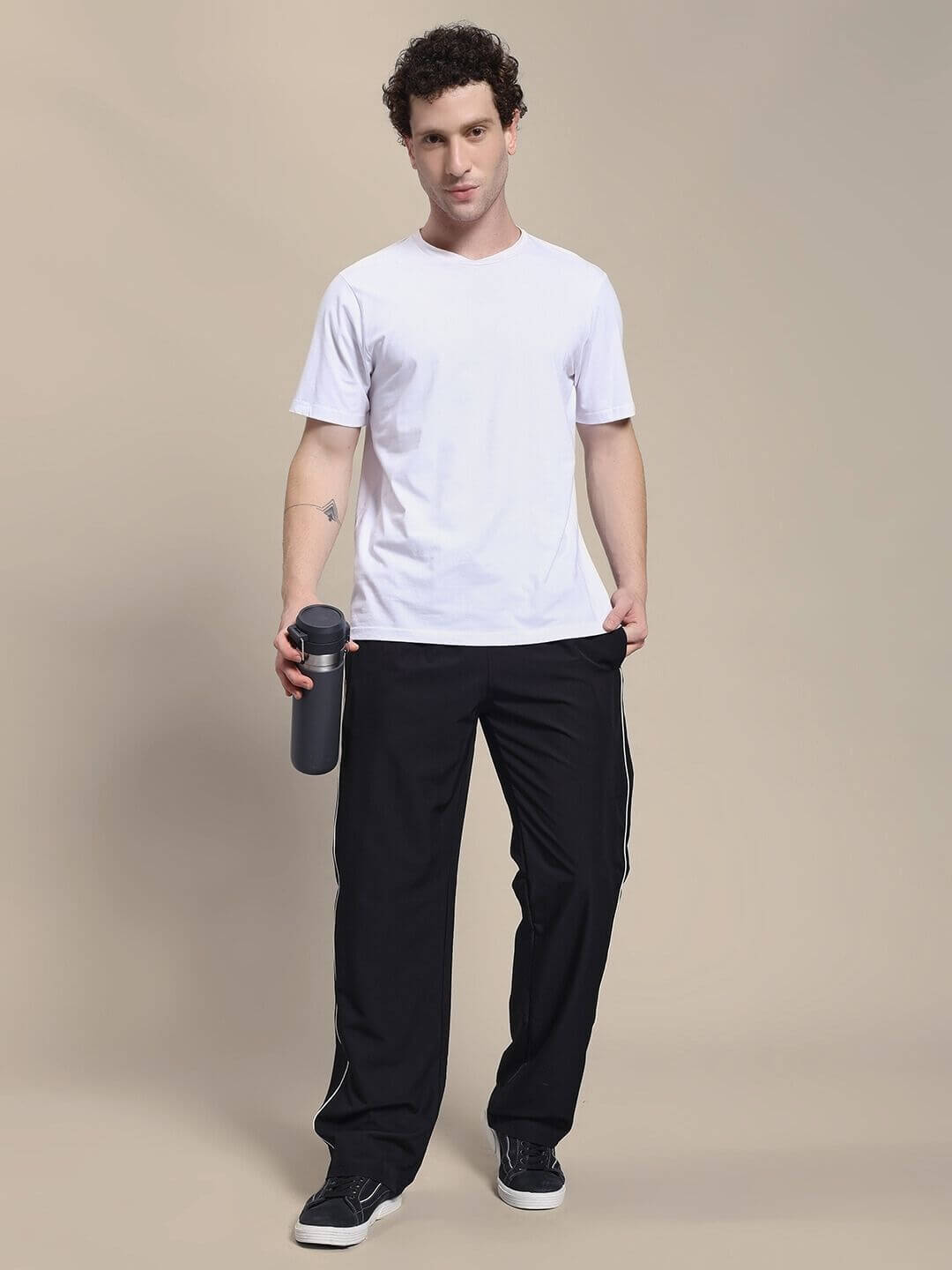 Man wearing TURBO TRACK RELAXED-FIT JOGGERS BLACK holding a water bottle