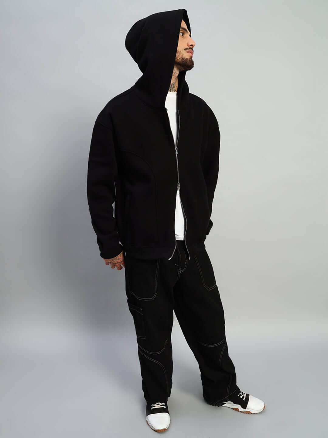 Model wearing WEARDUDS TWO FOLD ZIPPER HOODIE BLACK with hood up and casual stance