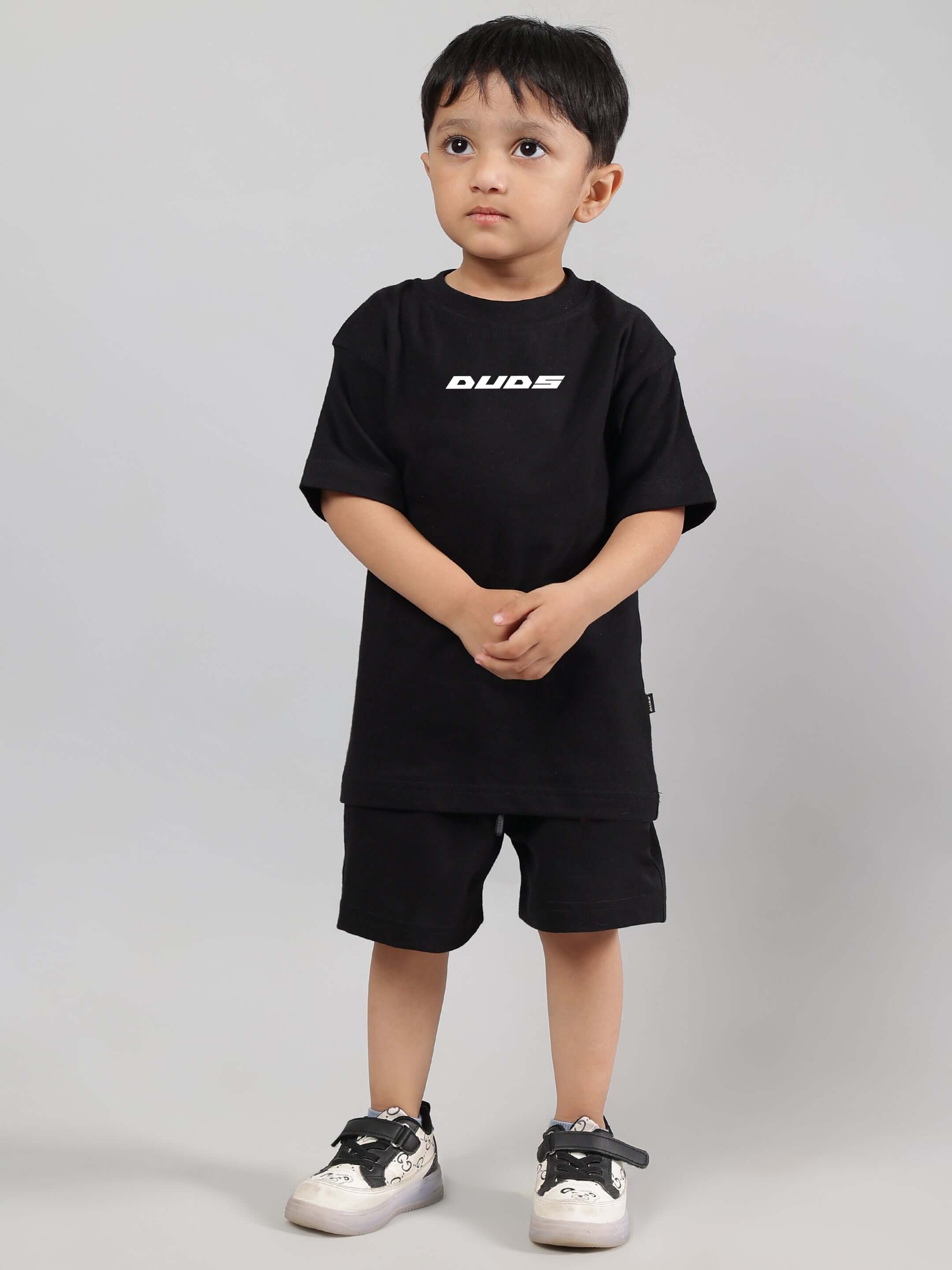 Child wearing ENJOY THE WIND CO-ORD FOR BOYS GIRLS BLACK, featuring a stylish black top and shorts set with "Dude" text design.