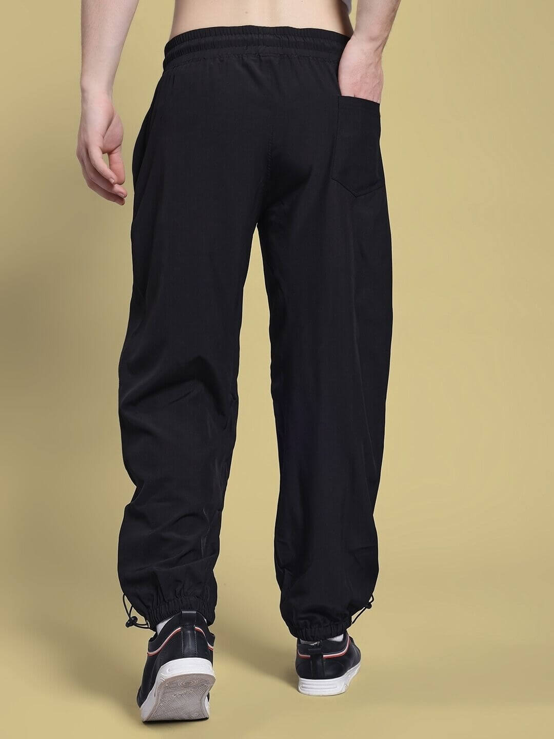 Rear view of UNISON RELAXED-FIT JOGGERS BLACK RED showcasing elastic waistband and cuffed ankles for kids.