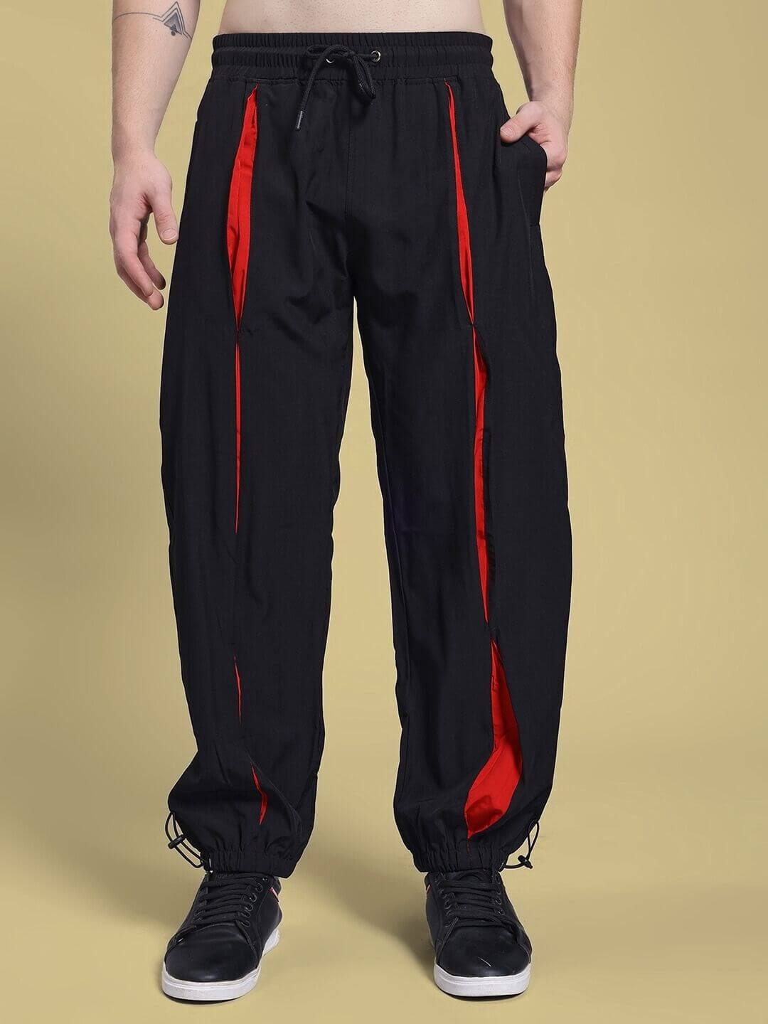 Person wearing UNISON RELAXED FIT CO-ORD SET BLACK RED joggers with red accents for casual style and comfort.