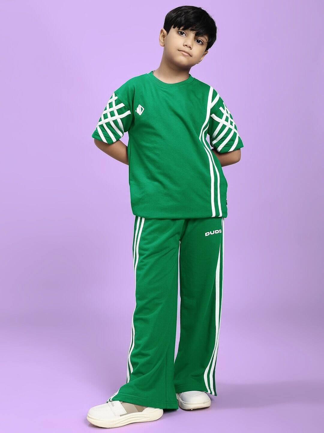 Child in UNITED STRIPE CO-ORD SET FOR BOYS GIRLS GREEN with sporty stripe details standing confidently.