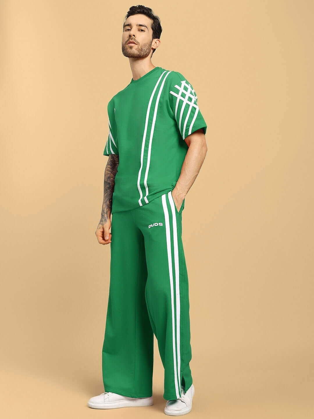 Model wearing UNITED STRIPE CO-ORD SET GREEN with white stripe detailing, showcasing bold style and comfort for streetwear fashion.