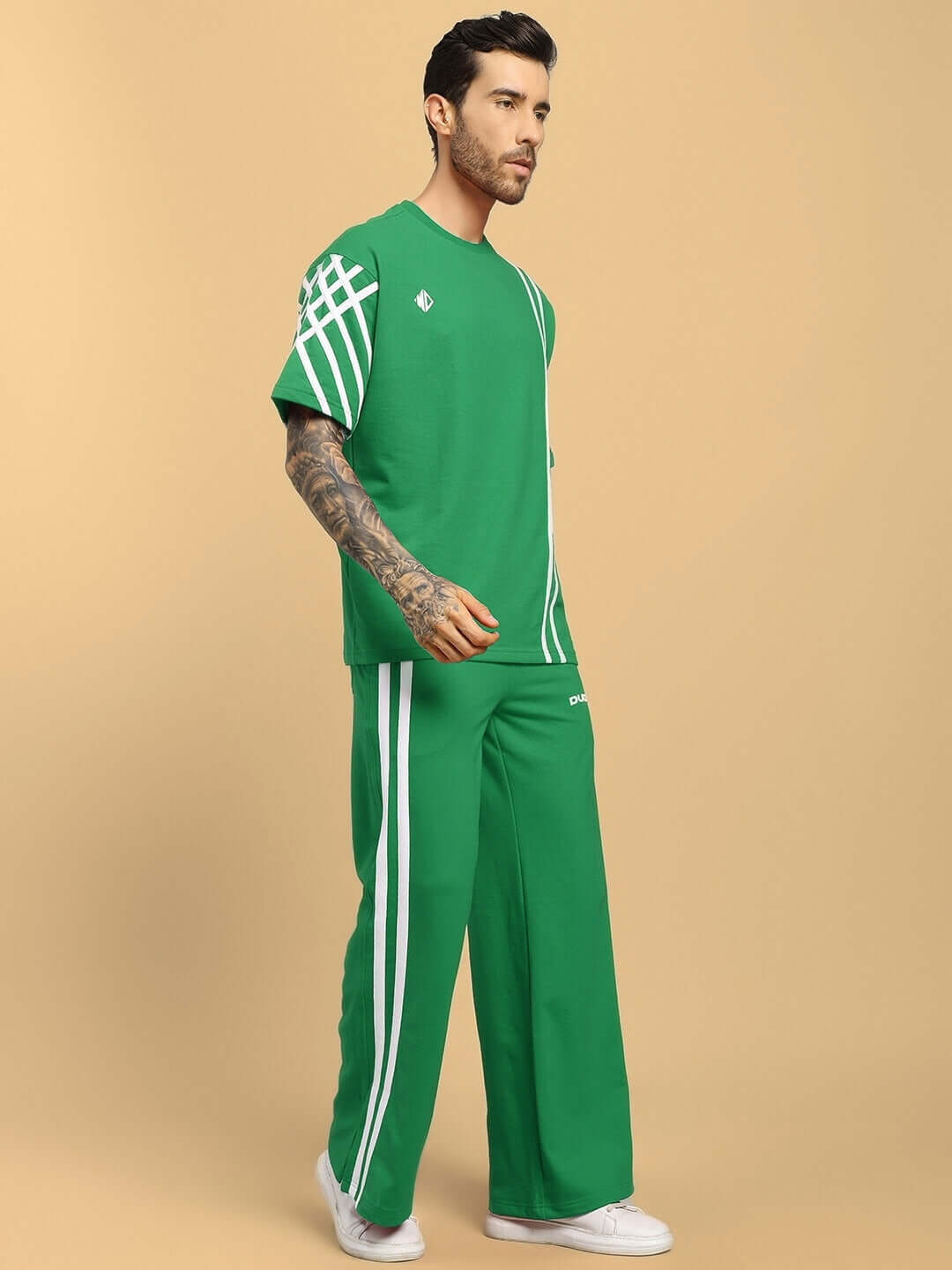 Model wearing UNITED STRIPE CO-ORD SET GREEN with clean stripe detailing on a fresh green base for bold streetwear style.