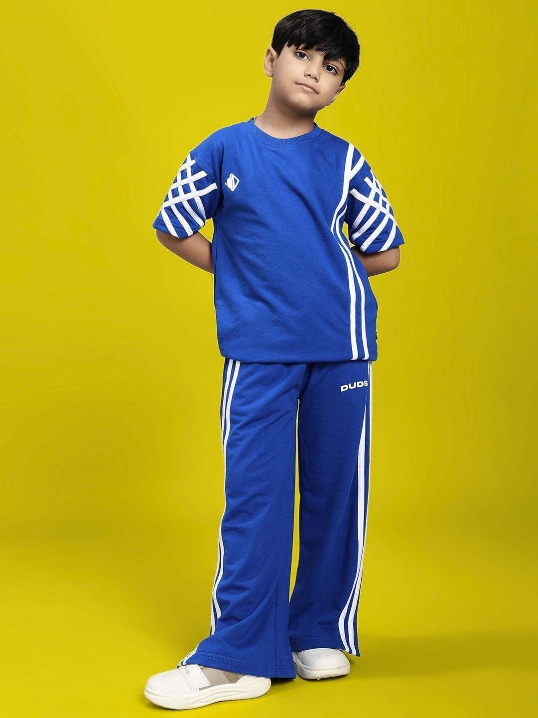 Child wearing UNITED STRIPE JOGGER FOR BOYS AND GIRLS BLUE against yellow background.