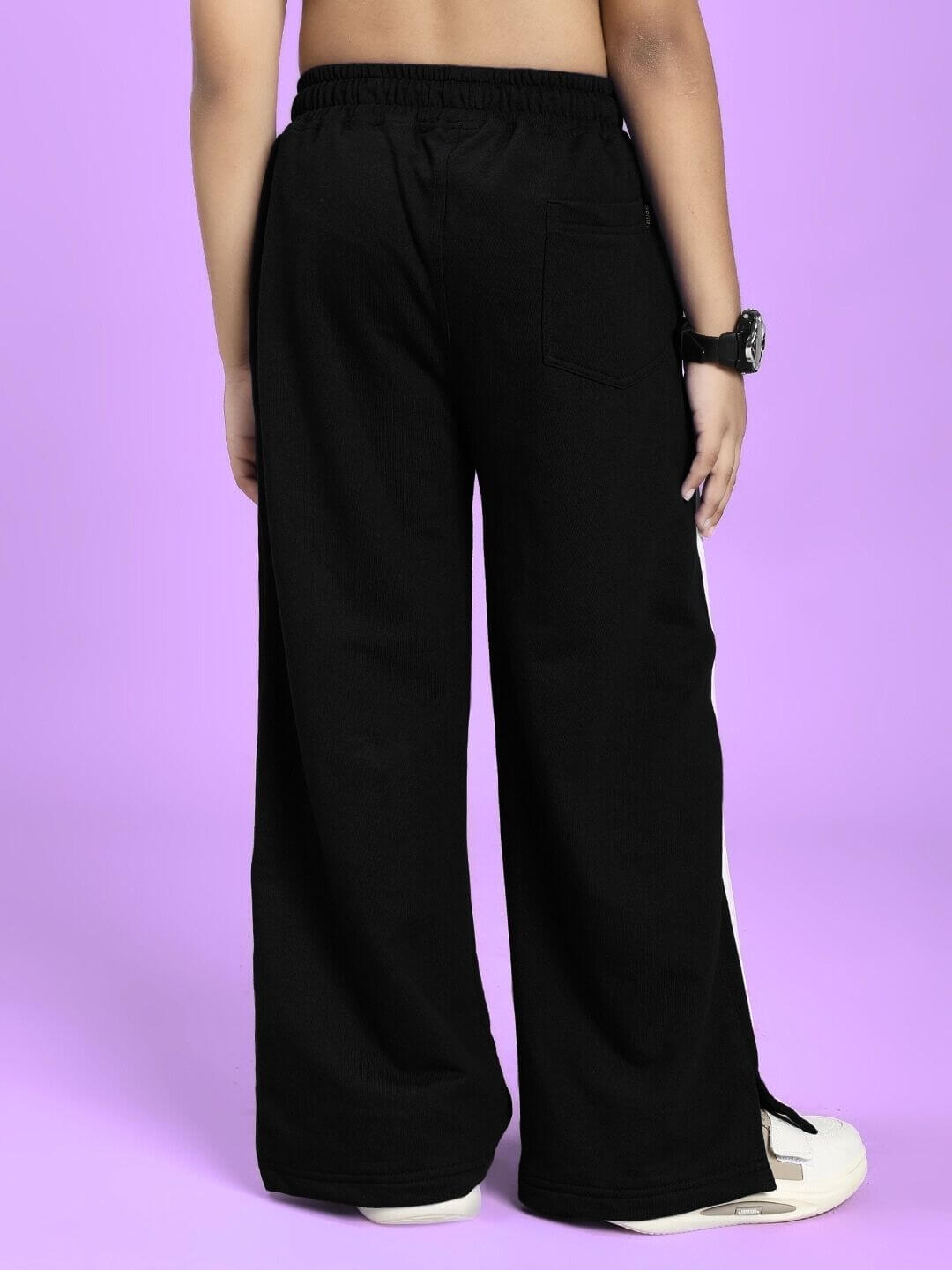 Back view of UNITED STRIPE JOGGER FOR BOYS AND GIRLS BLACK worn by a child, showing the sporty design and stripe detailing.