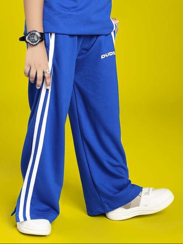 UNITED STRIPE JOGGER FOR BOYS AND GIRLS BLUE with side stripes and casual footwear on yellow background