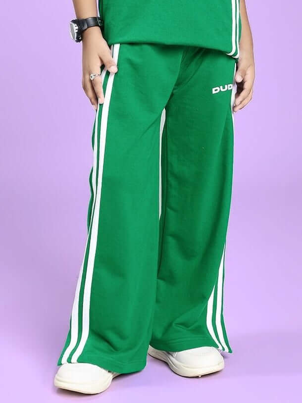 Child wearing a UNITED STRIPE JOGGER FOR BOYS AND GIRLS GREEN with sporty stripe details.