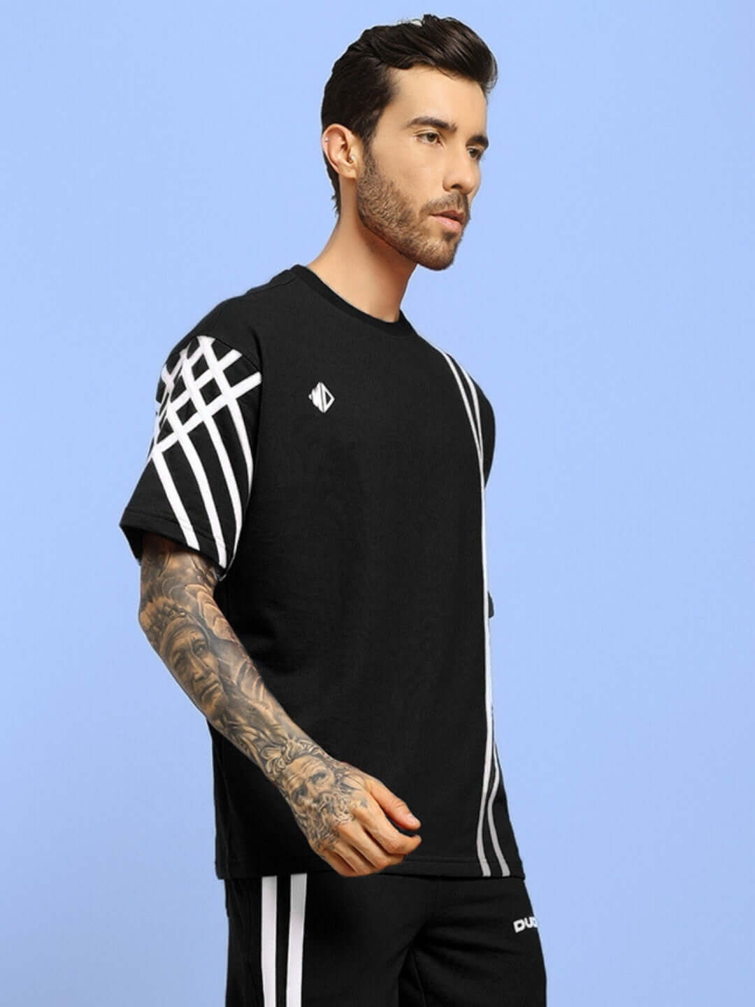 Man wearing a black United Stripe oversized T-shirt made of premium heavy gauge fabric, featuring a stylish stripe design on sleeves.